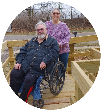 man in wheelchair on ramp with woman standing behind him