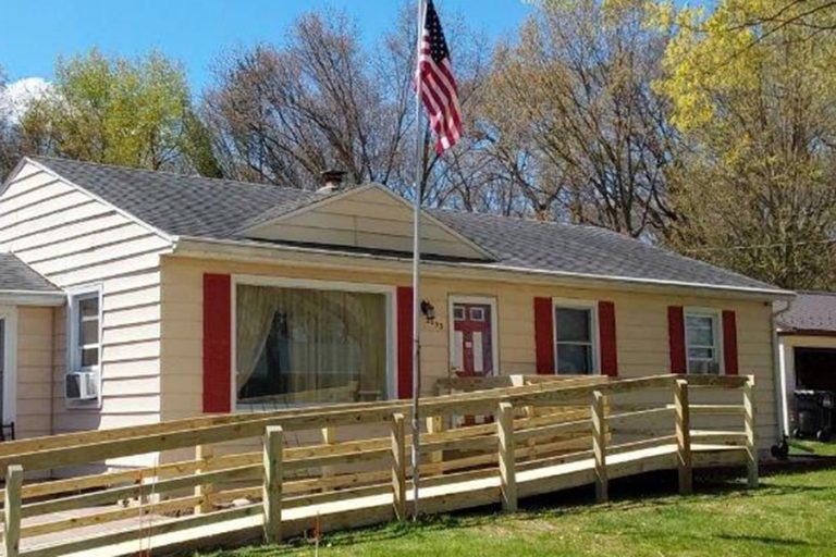 home with ramp and a flag
