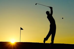 golfer swinging in sunrise